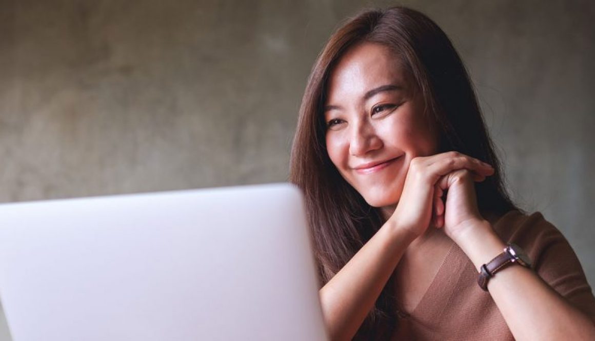 How to Make Your Website Feel Instantly More Helpful - girl smiling looking at laptop