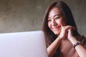 How to Make Your Website Feel Instantly More Helpful - girl smiling looking at laptop
