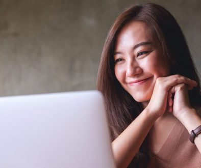 How to Make Your Website Feel Instantly More Helpful - girl smiling looking at laptop
