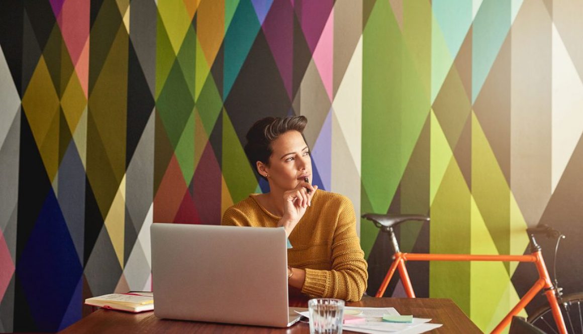 Woman with laptop thinking colorful background