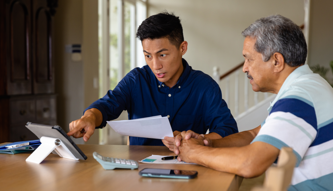 Dad and son are discussing business at a table with a tablet