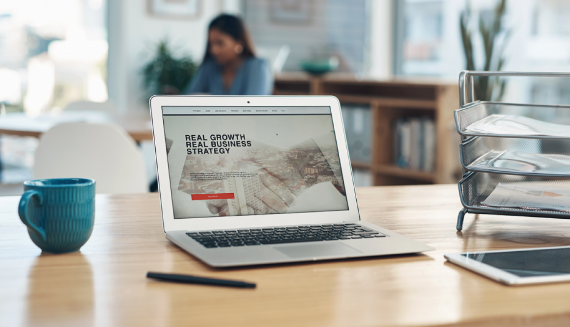 Website on laptop on desk with coffee cup