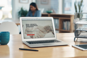 Website on laptop on desk with coffee cup