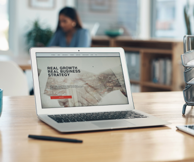 Website on laptop on desk with coffee cup