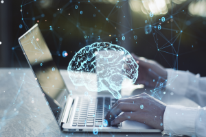 Brain graphic over laptop with person typing
