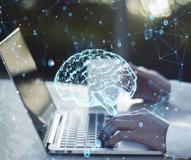 Brain graphic over laptop with person typing